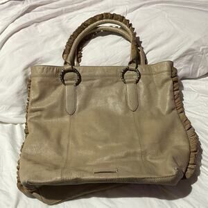 BCBGGirls tan leather handbag euc hand held ruffled handles brass rings w/charm
